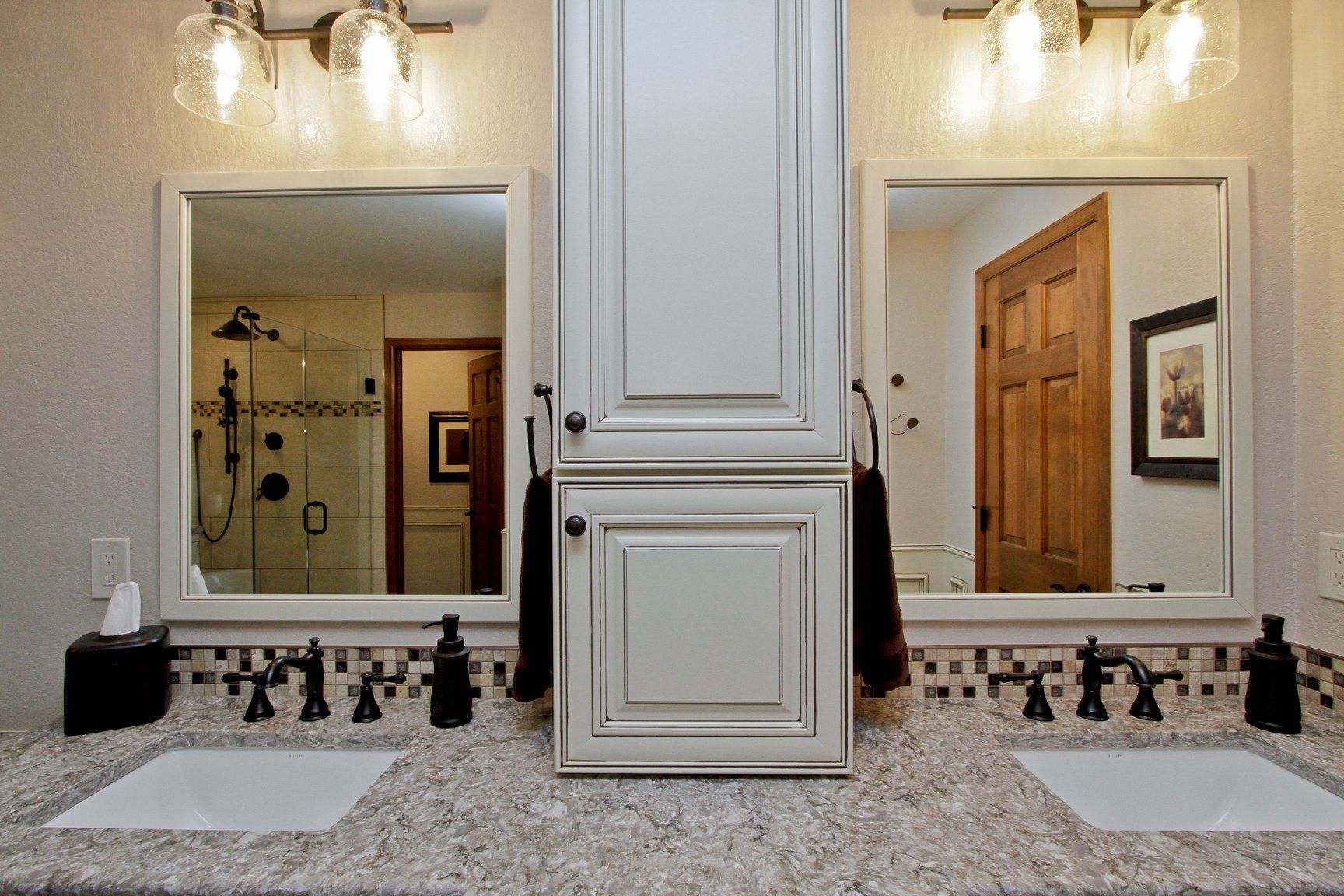 A bathroom with two sinks and two mirrors