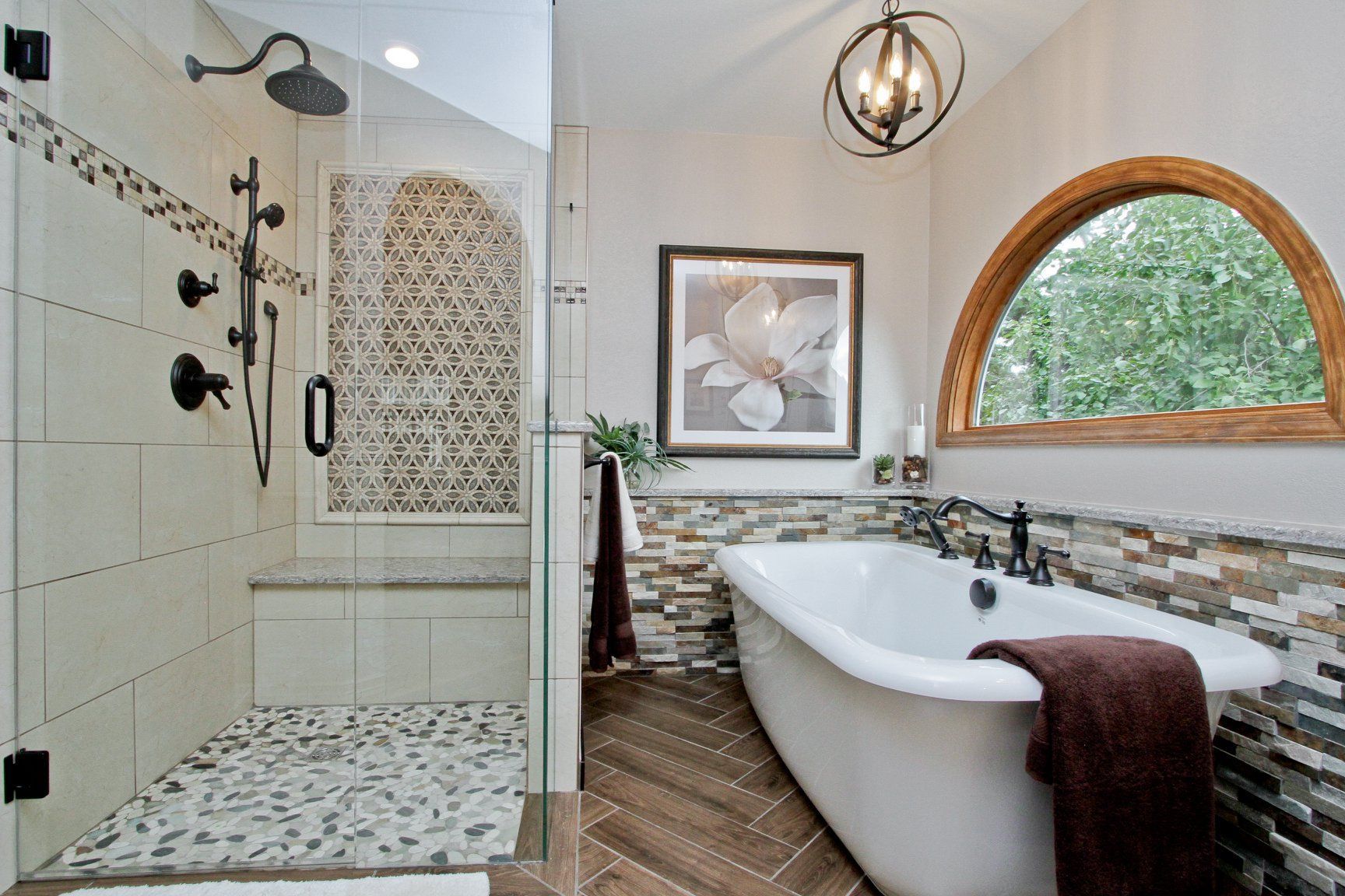 A bathroom with a tub , shower , and window.