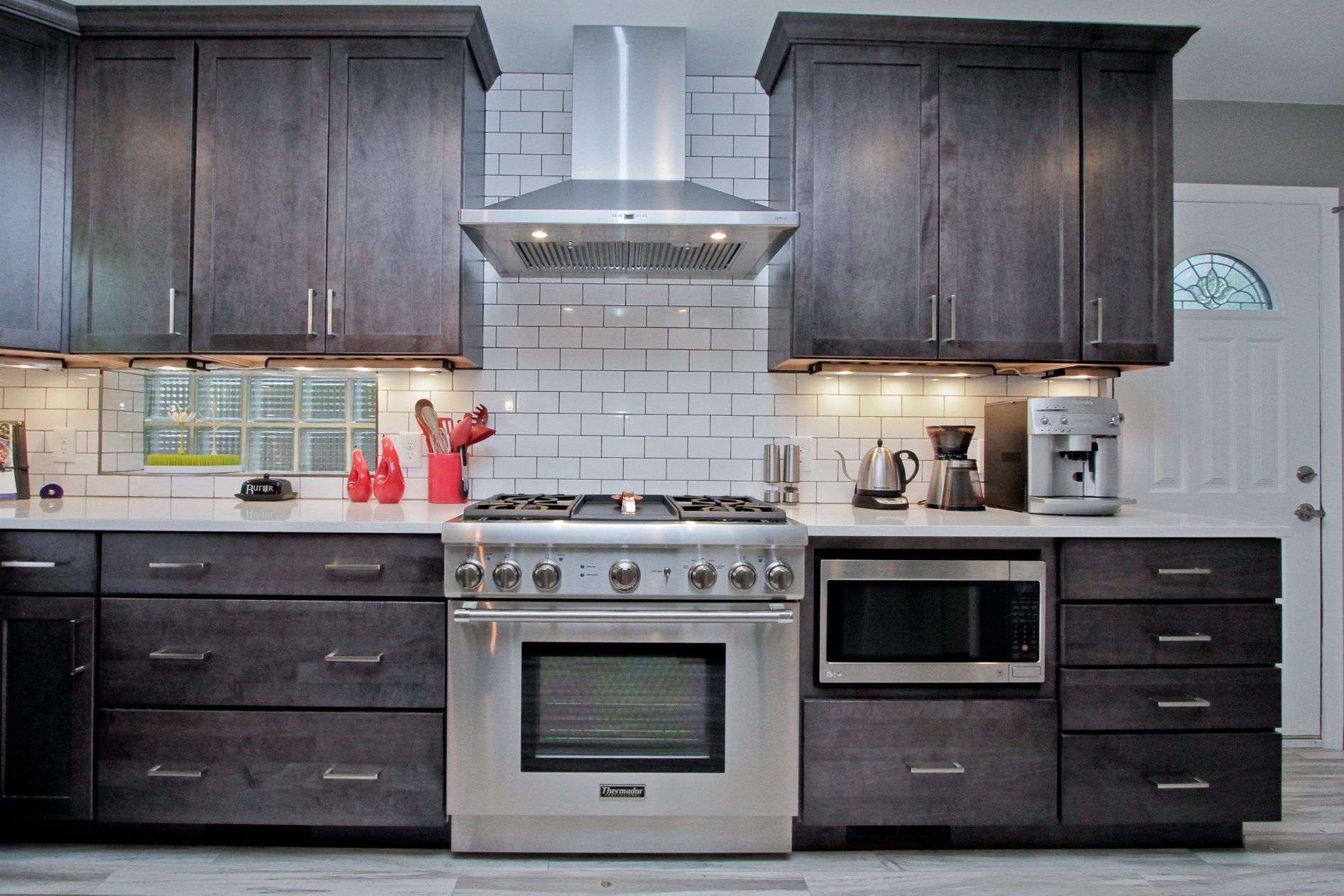 A kitchen with stainless steel appliances and gray cabinets
