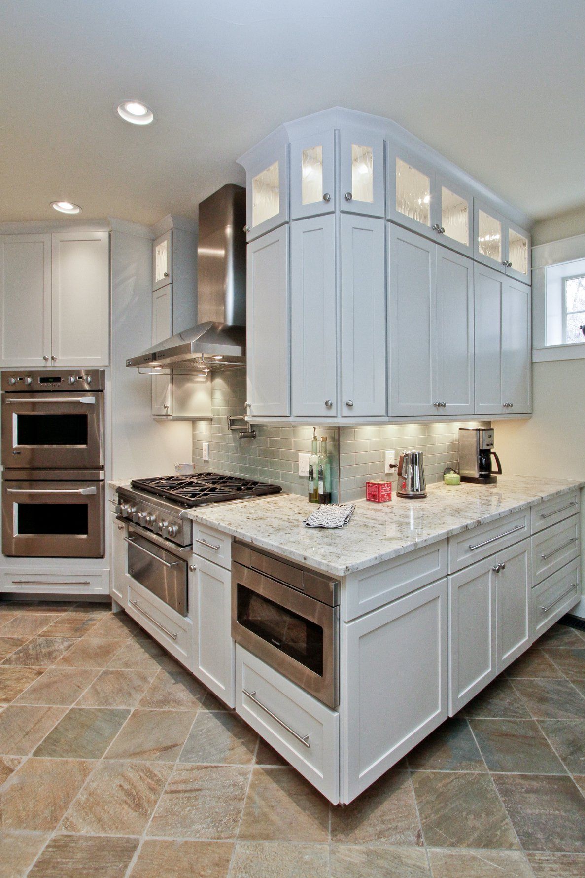 A kitchen with white cabinets and stainless steel appliances