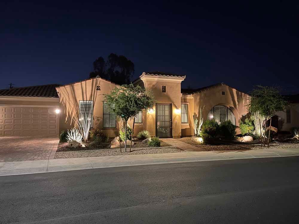 A large house with a garage is lit up at night.