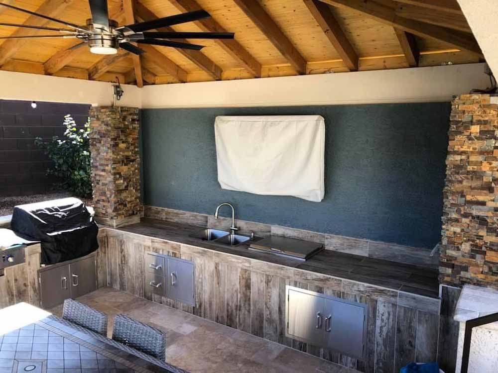A kitchen with a table , sink , and ceiling fan.