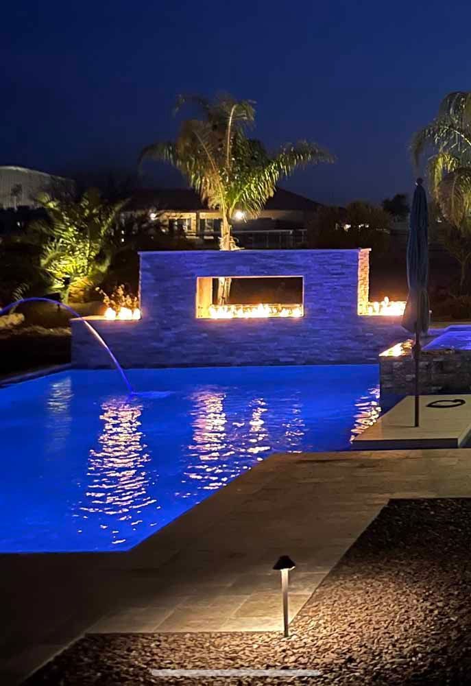 A large swimming pool is lit up at night