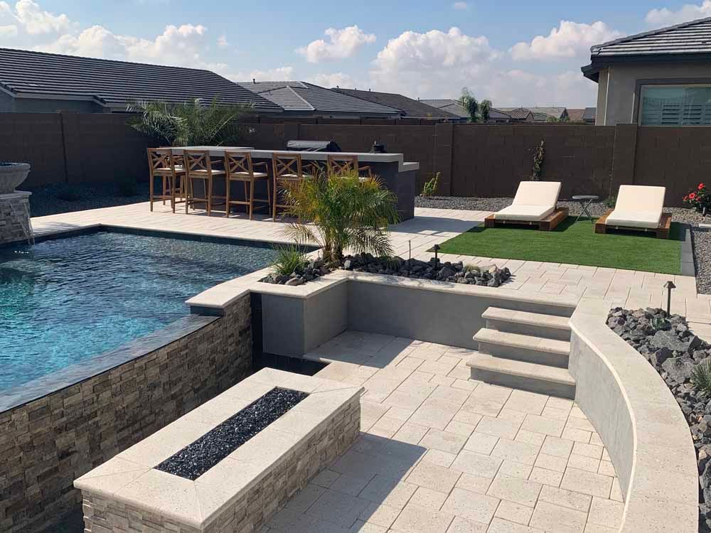 There is a large swimming pool in the backyard with a fire pit.