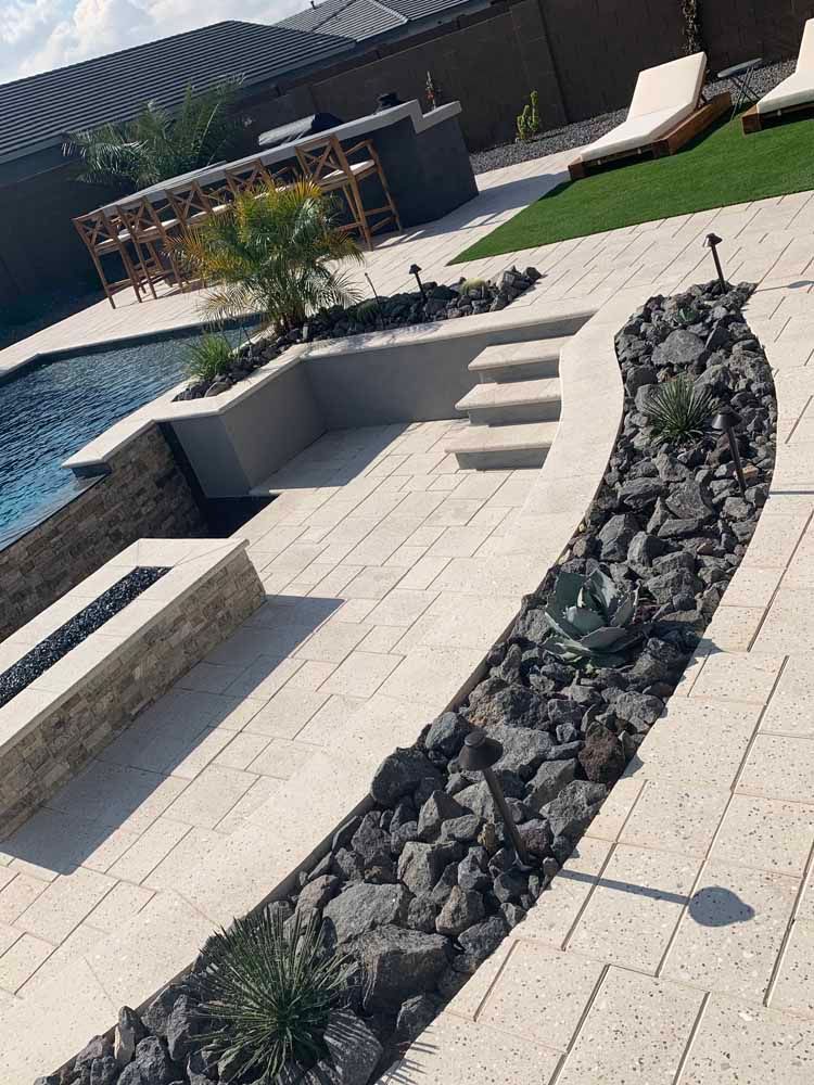 A patio with a swimming pool and a bar in the background.