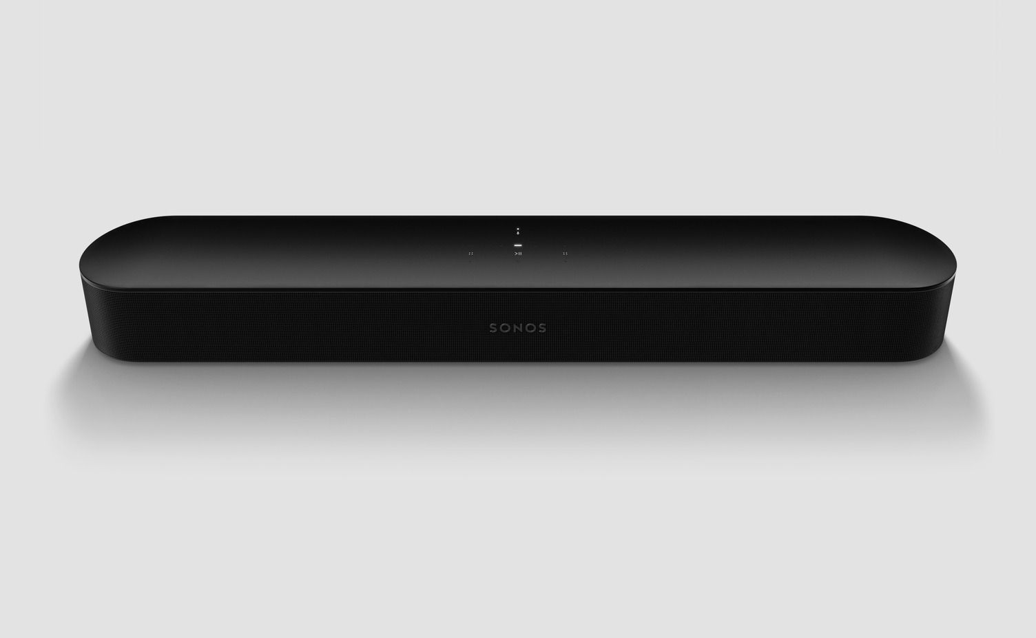 A black sound bar is sitting on a white surface.