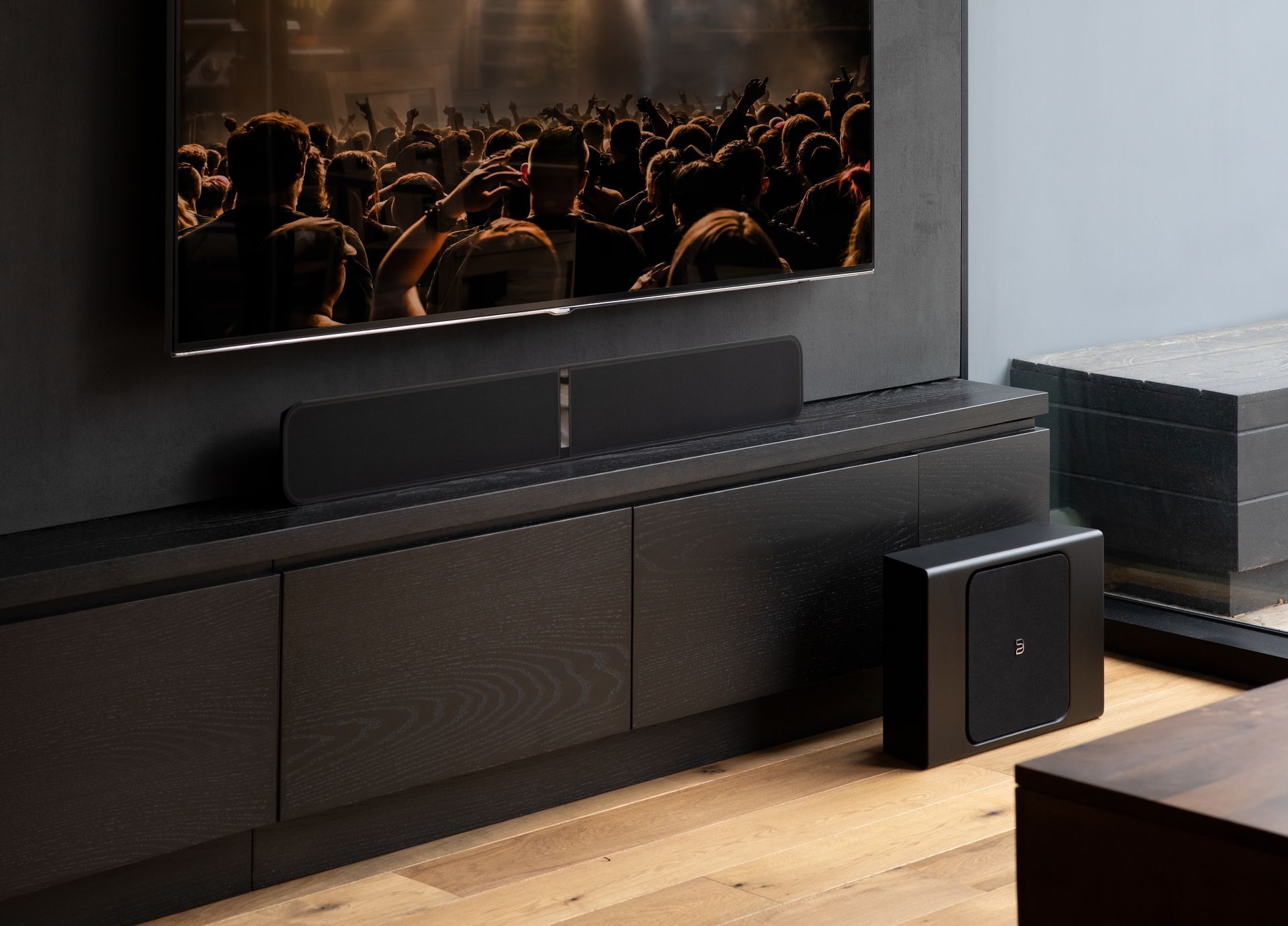 A living room with a flat screen tv and a subwoofer.
