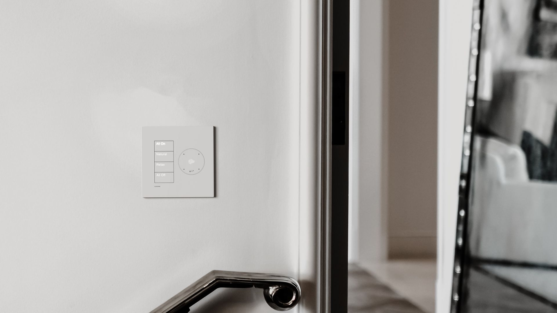 A black and white photo of a door with a light switch on it.