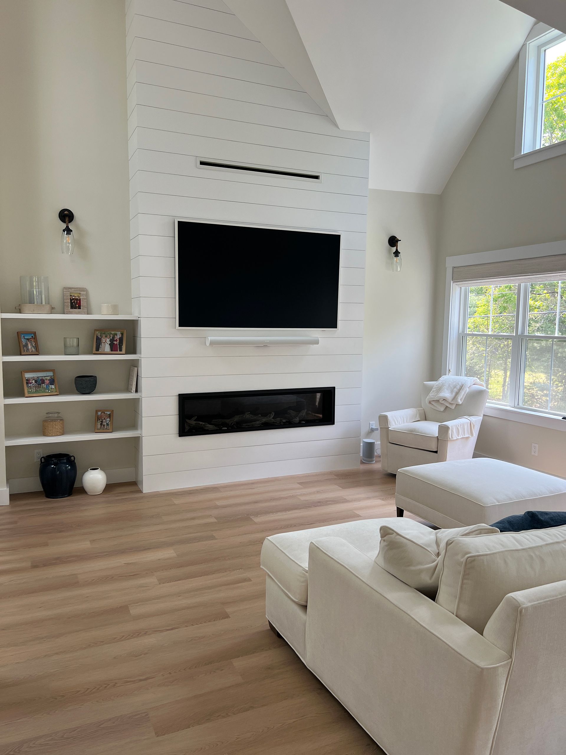 A living room with a fireplace and a flat-screen tv.