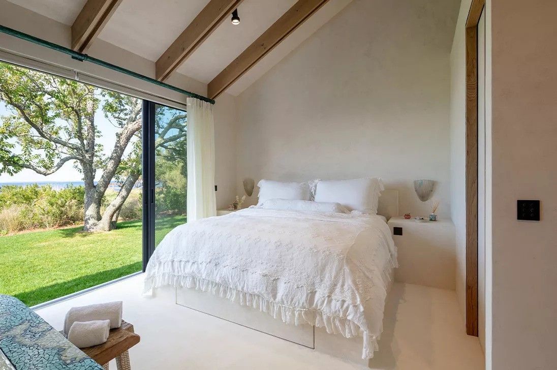 A bedroom with a large bed and a large window
