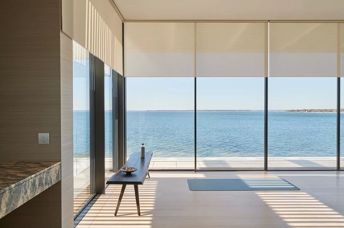 A table in the middle of the room with a view of the ocean