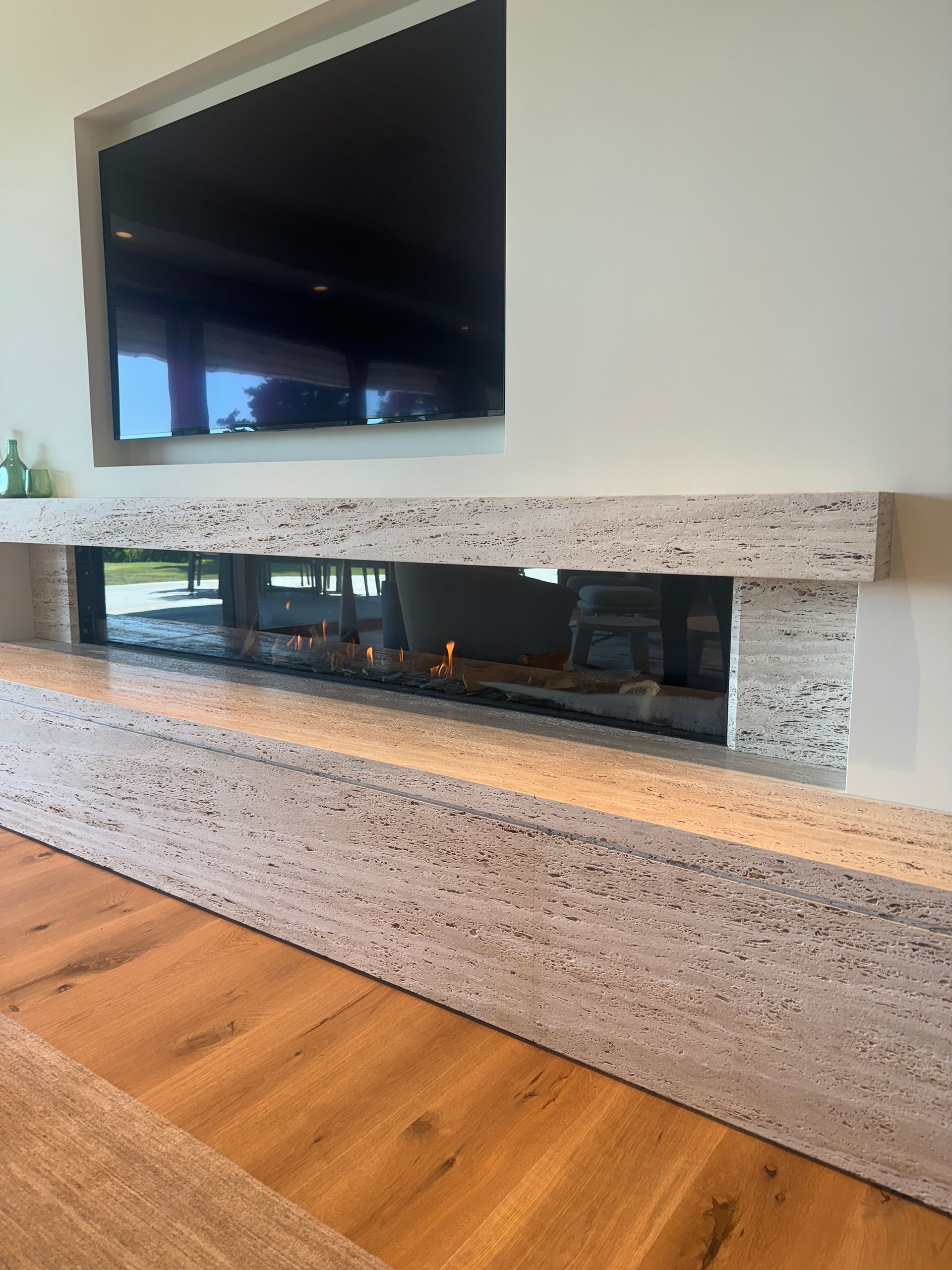 A living room with a fireplace and a flat-screen tv.