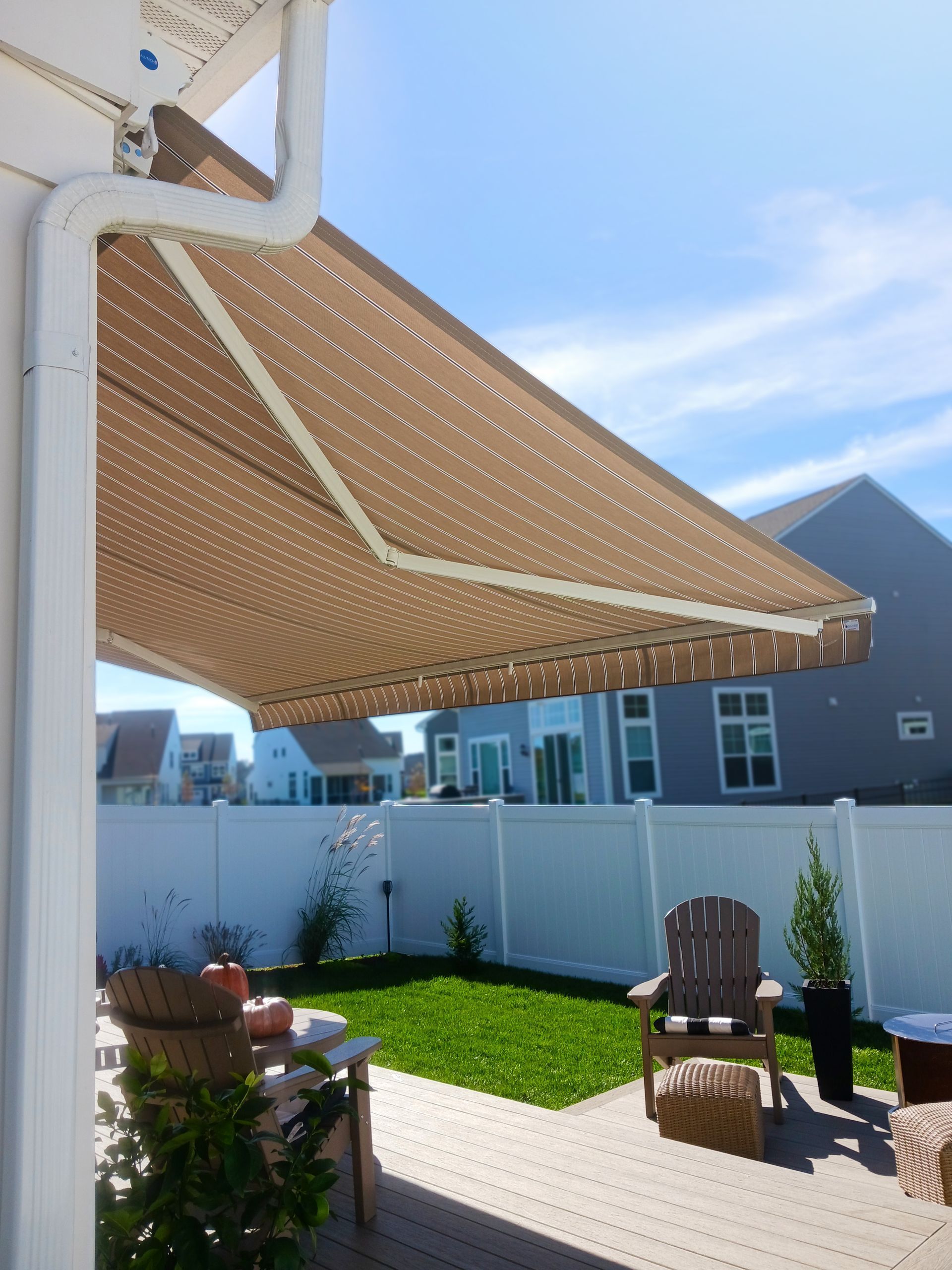 A patio with chairs and a table under an awning