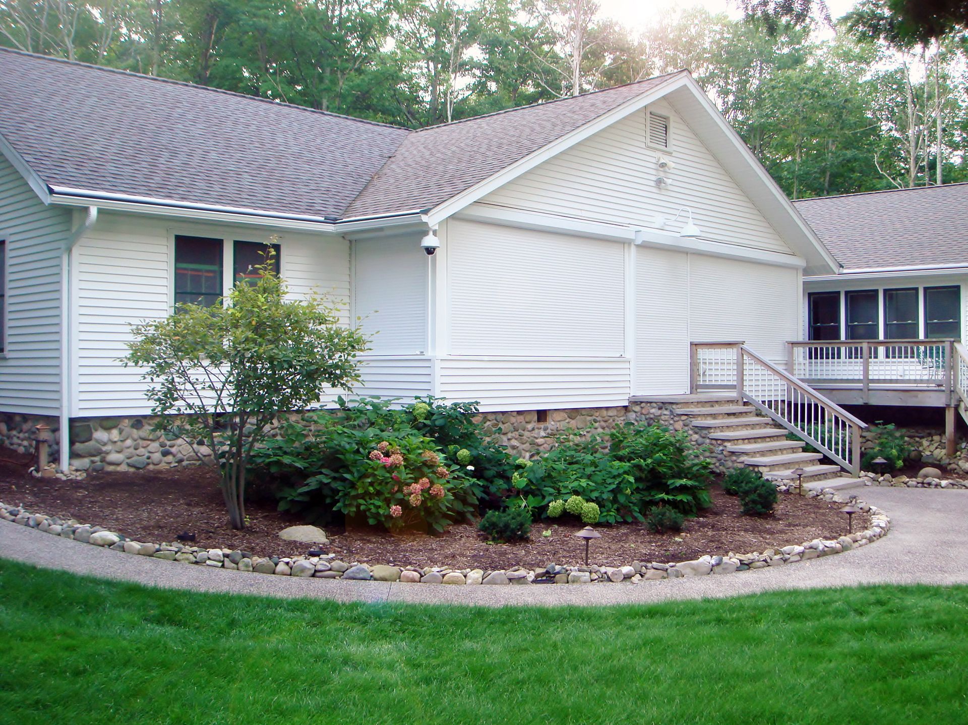 A white house with a brown roof and stairs