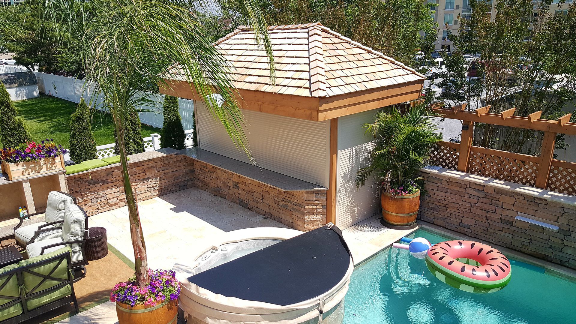 An aerial view of a swimming pool with a gazebo in the background