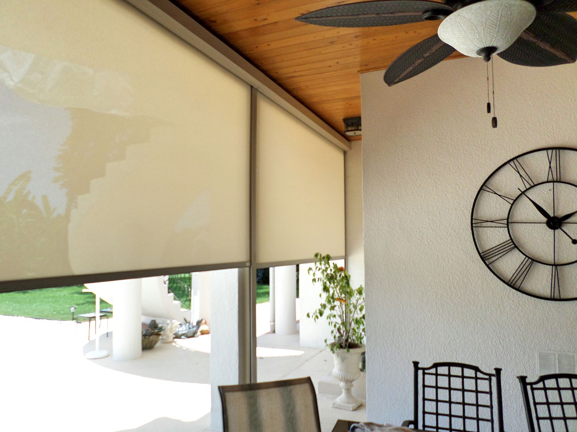 A room with a clock on the wall and a ceiling fan