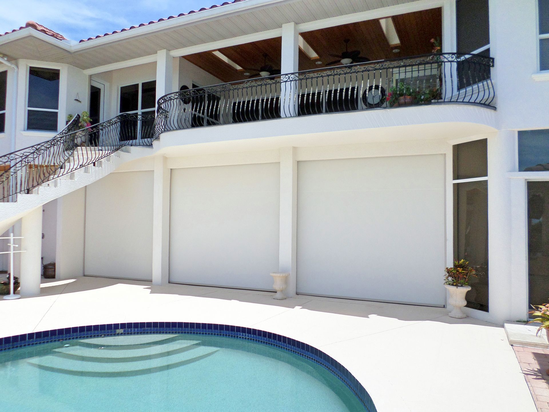A large white house with a swimming pool in front of it