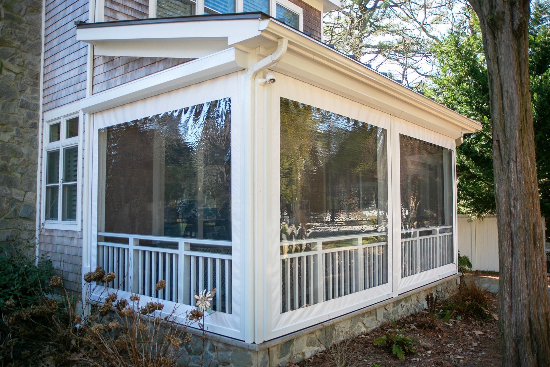A screened in porch on the side of a house
