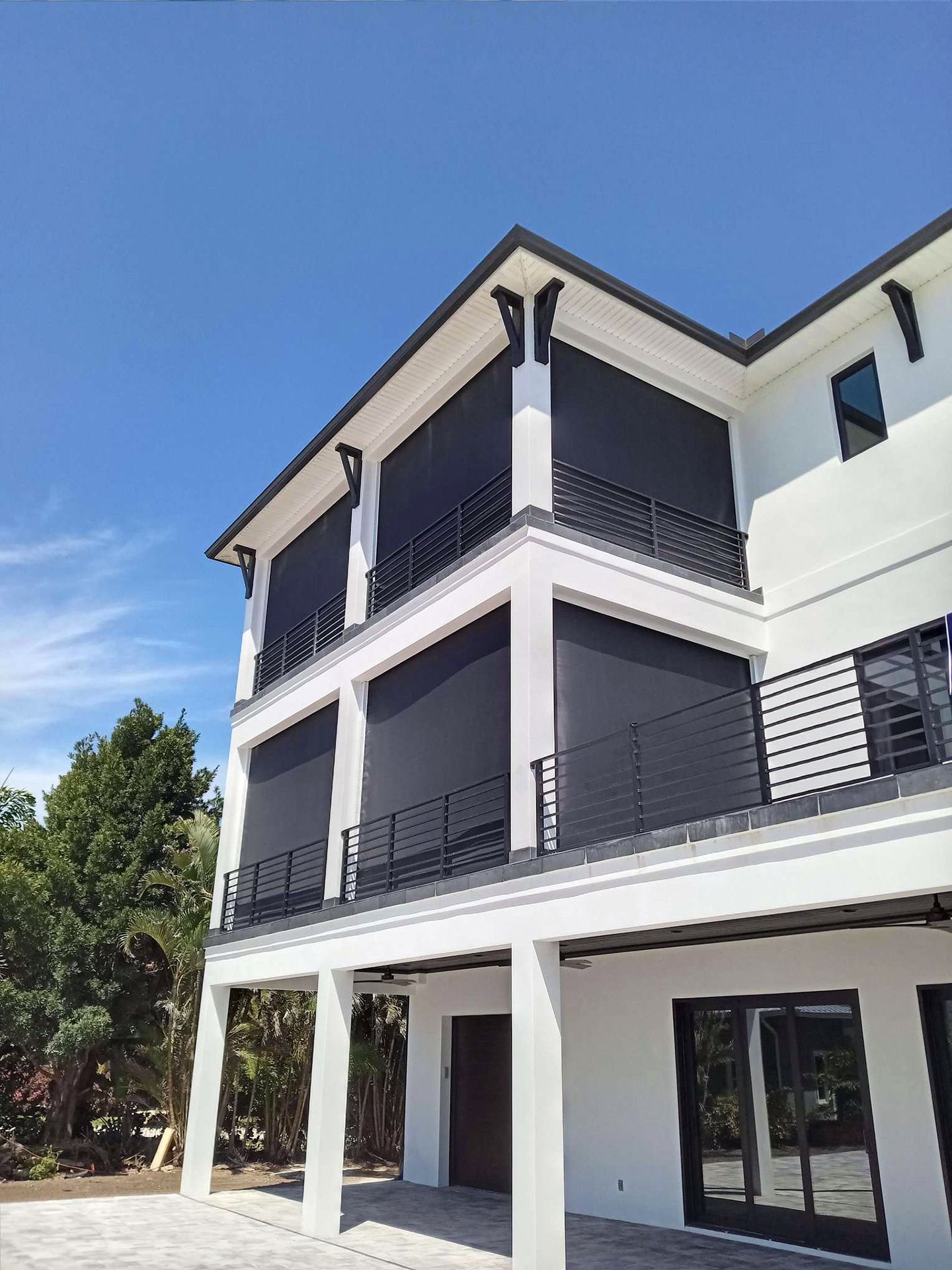 A large white house with black screen on the balconies