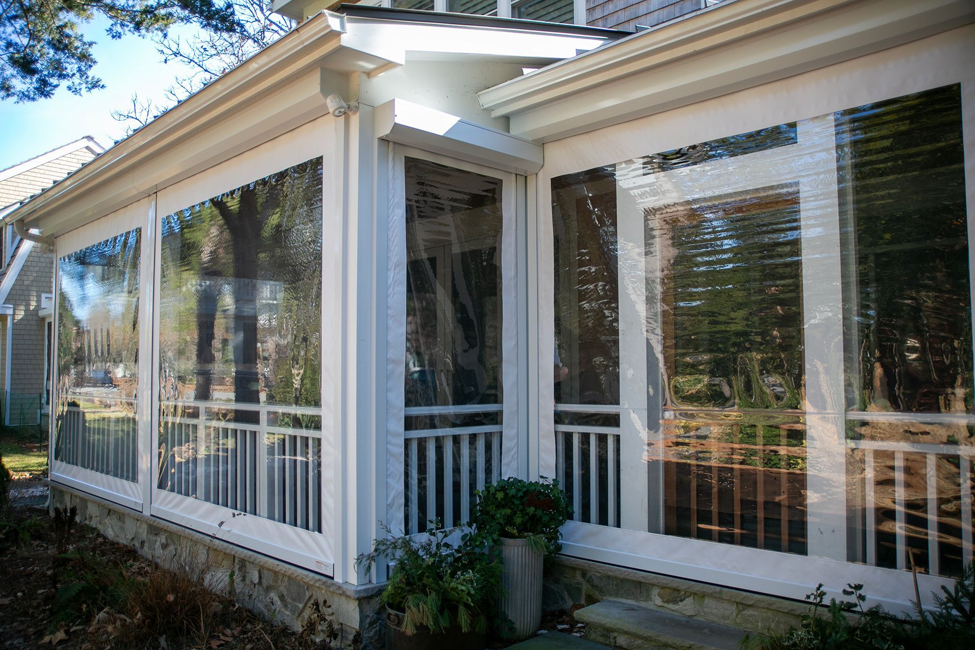 A screened in porch with lots of windows and a railing