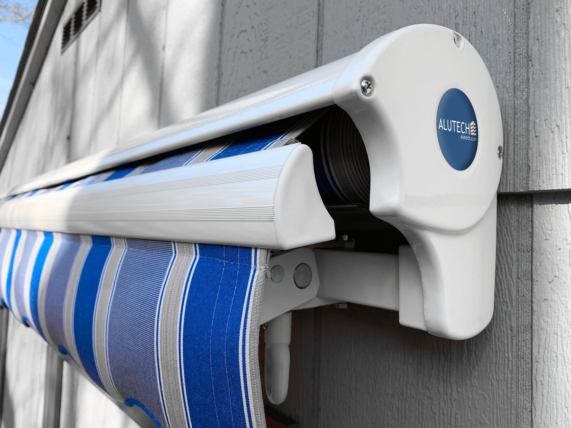 A blue and white striped awning is attached to the side of a building