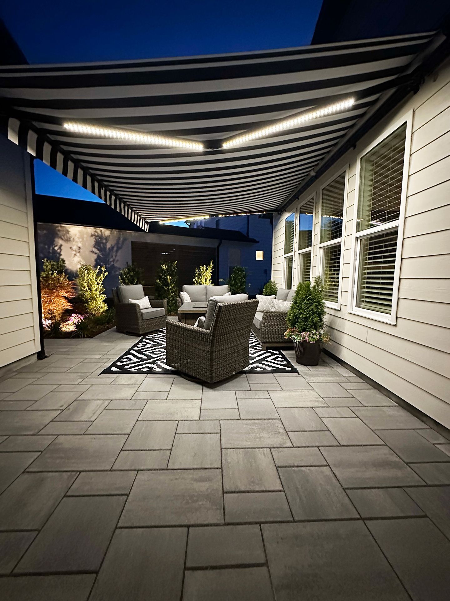 A patio with a striped awning over it