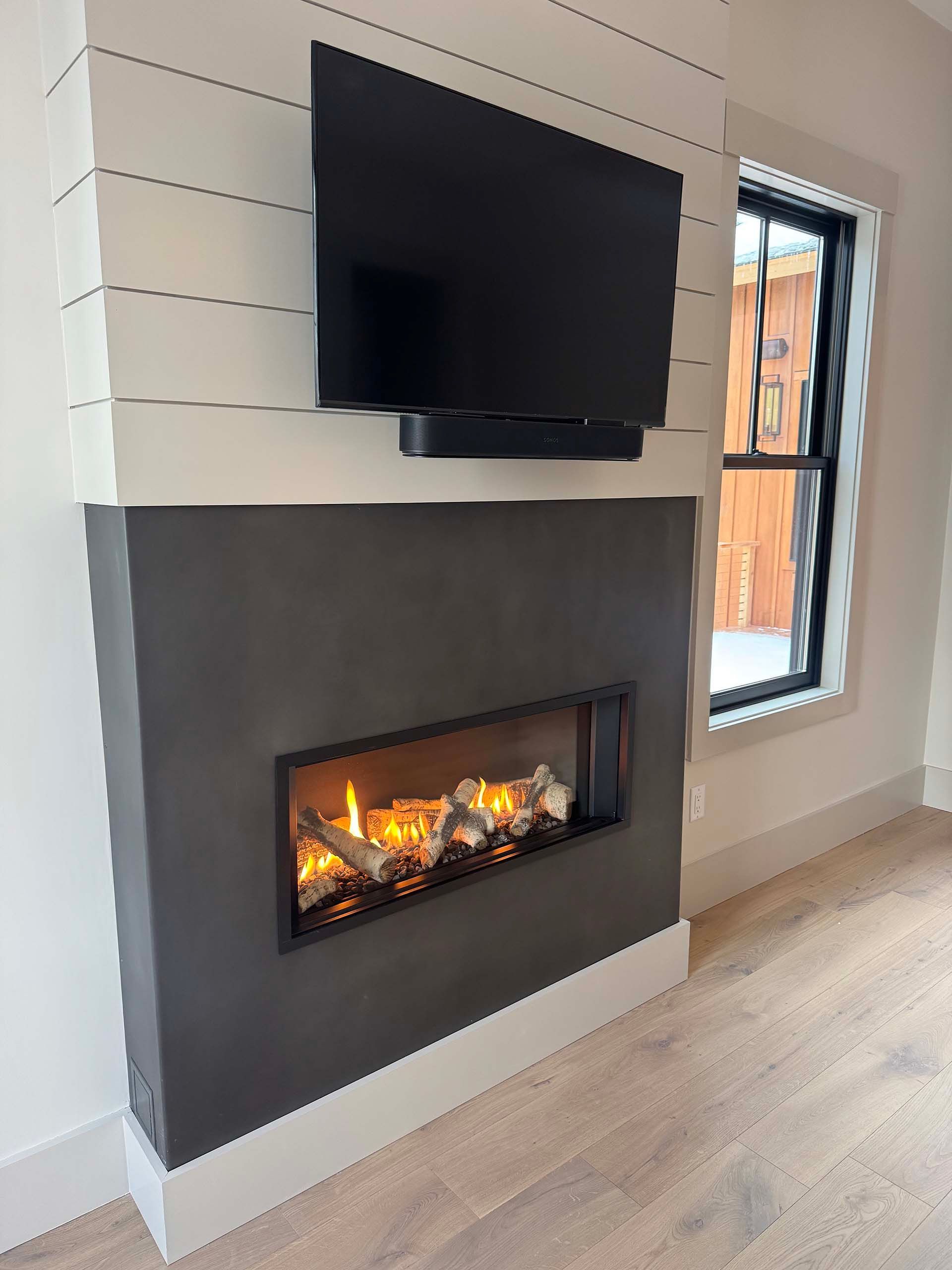 A fireplace with a flat screen tv above it in a living room.