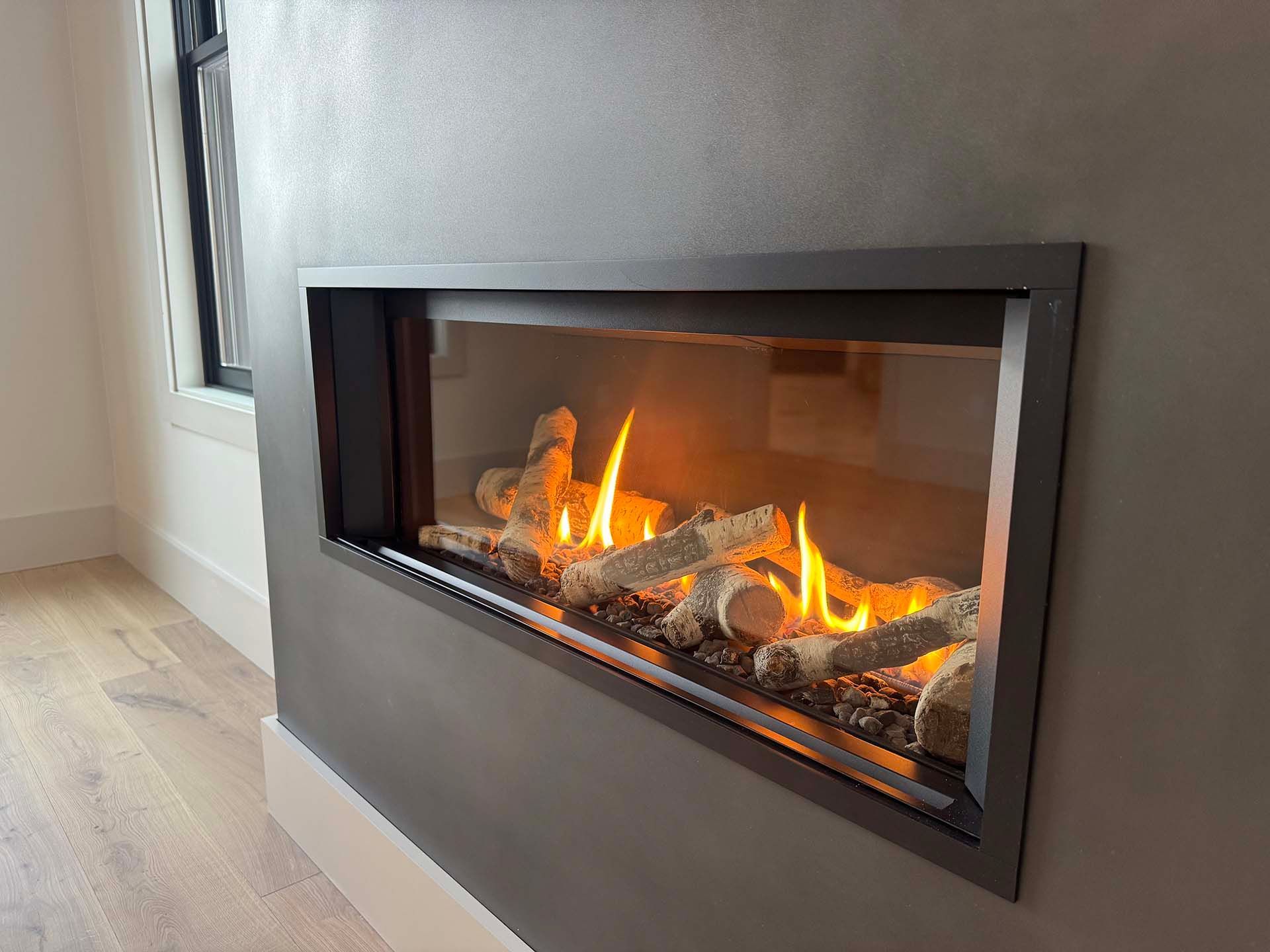 A fireplace with flames coming out of it in a living room.