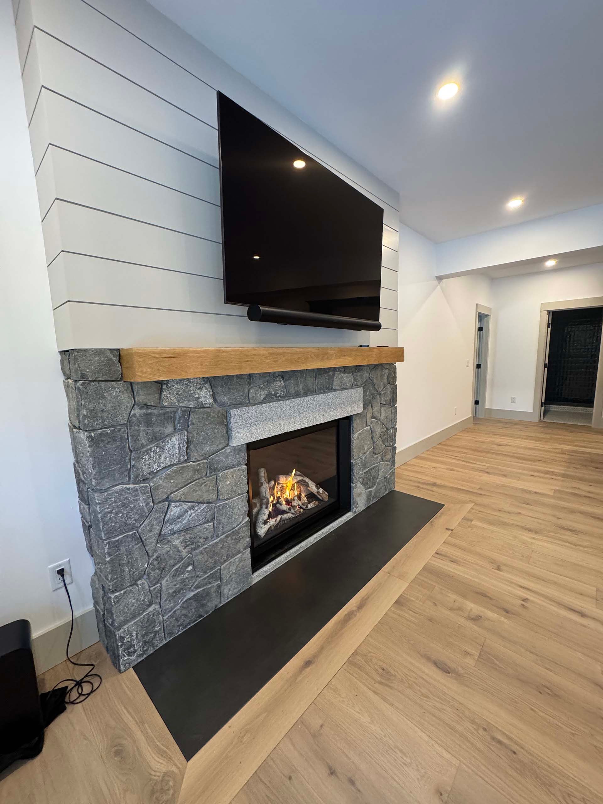 A living room with a fireplace and a flat screen tv on the wall.