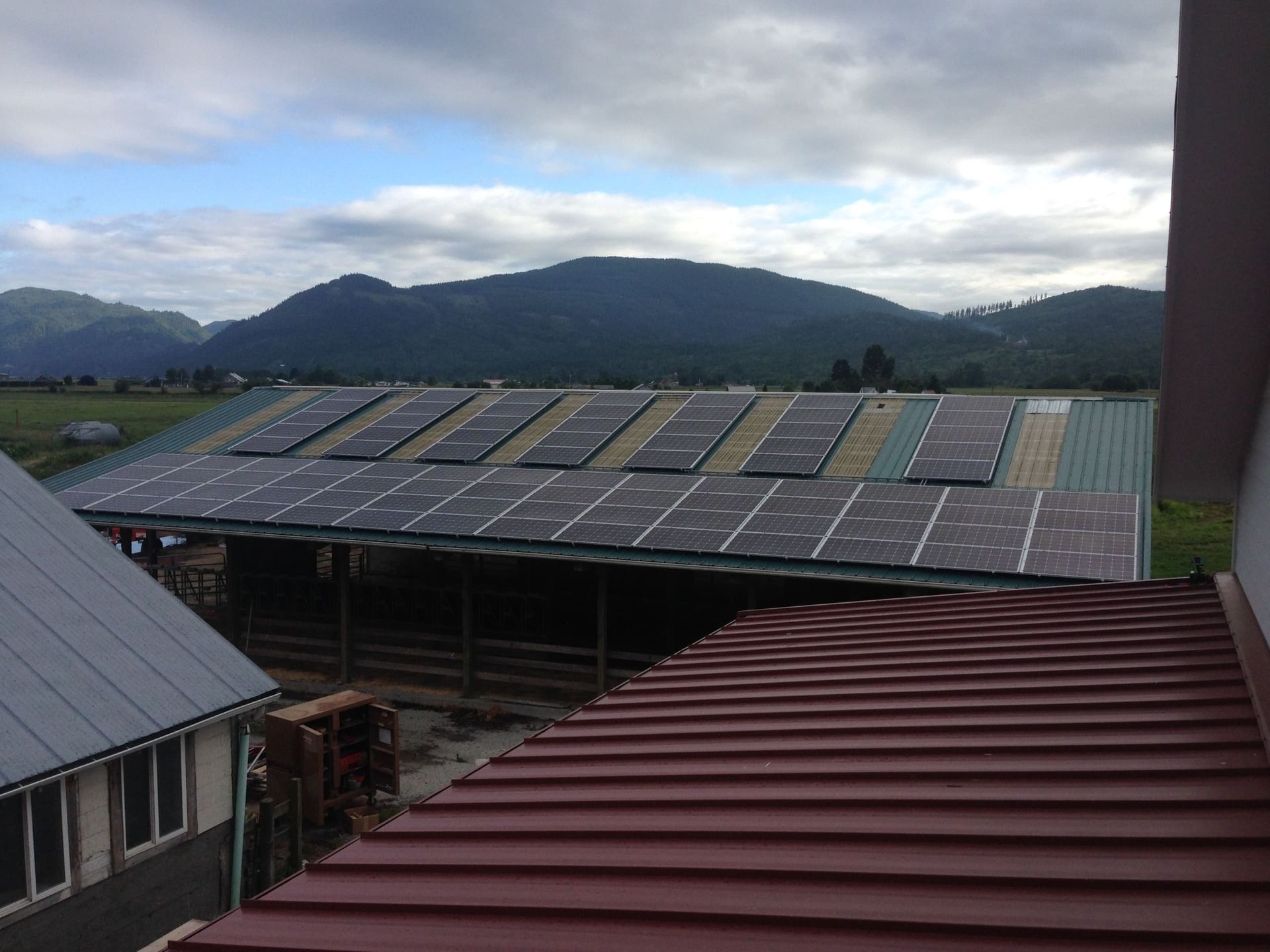 a roof with a lot of solar panels on it and mountains in the background