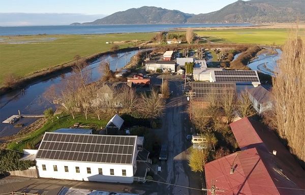 an aerial view of a house with solar panels on the roof