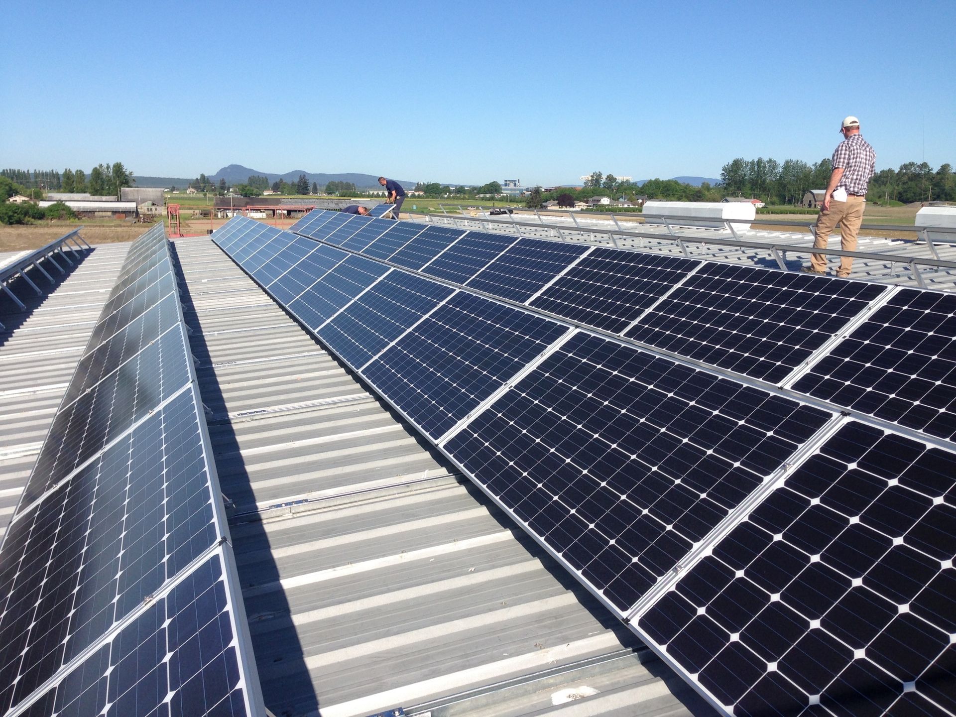 a man is standing on top of a roof with solar panels