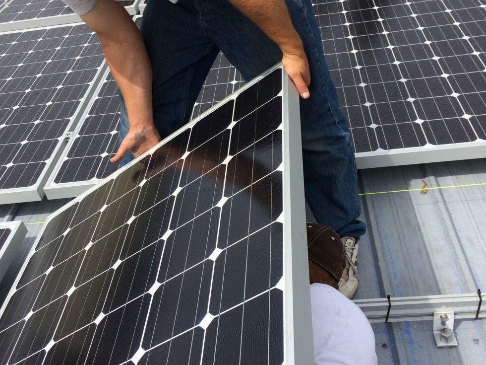 a man is installing solar panels on a roof