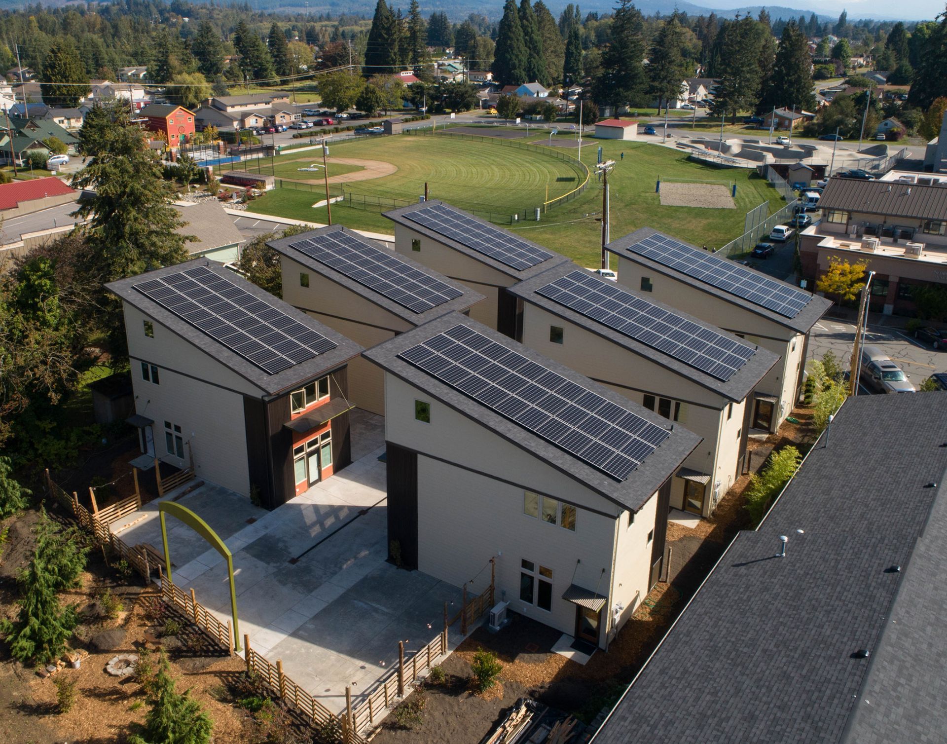 An aerial view of a row of houses with solar panels on the roofs