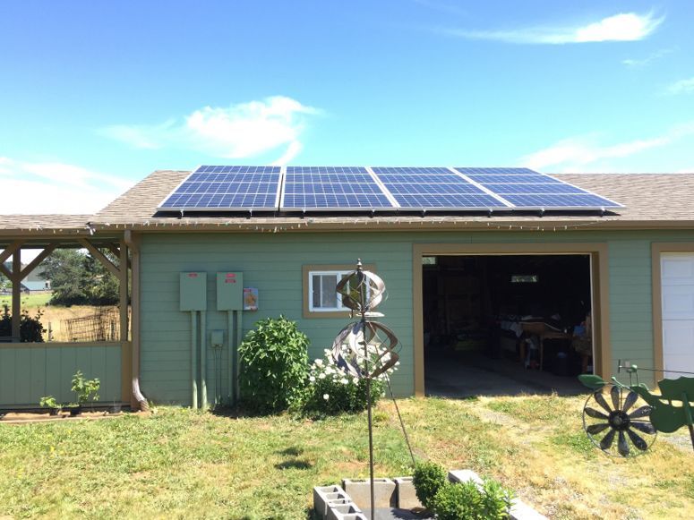 A green house with solar panels on the roof
