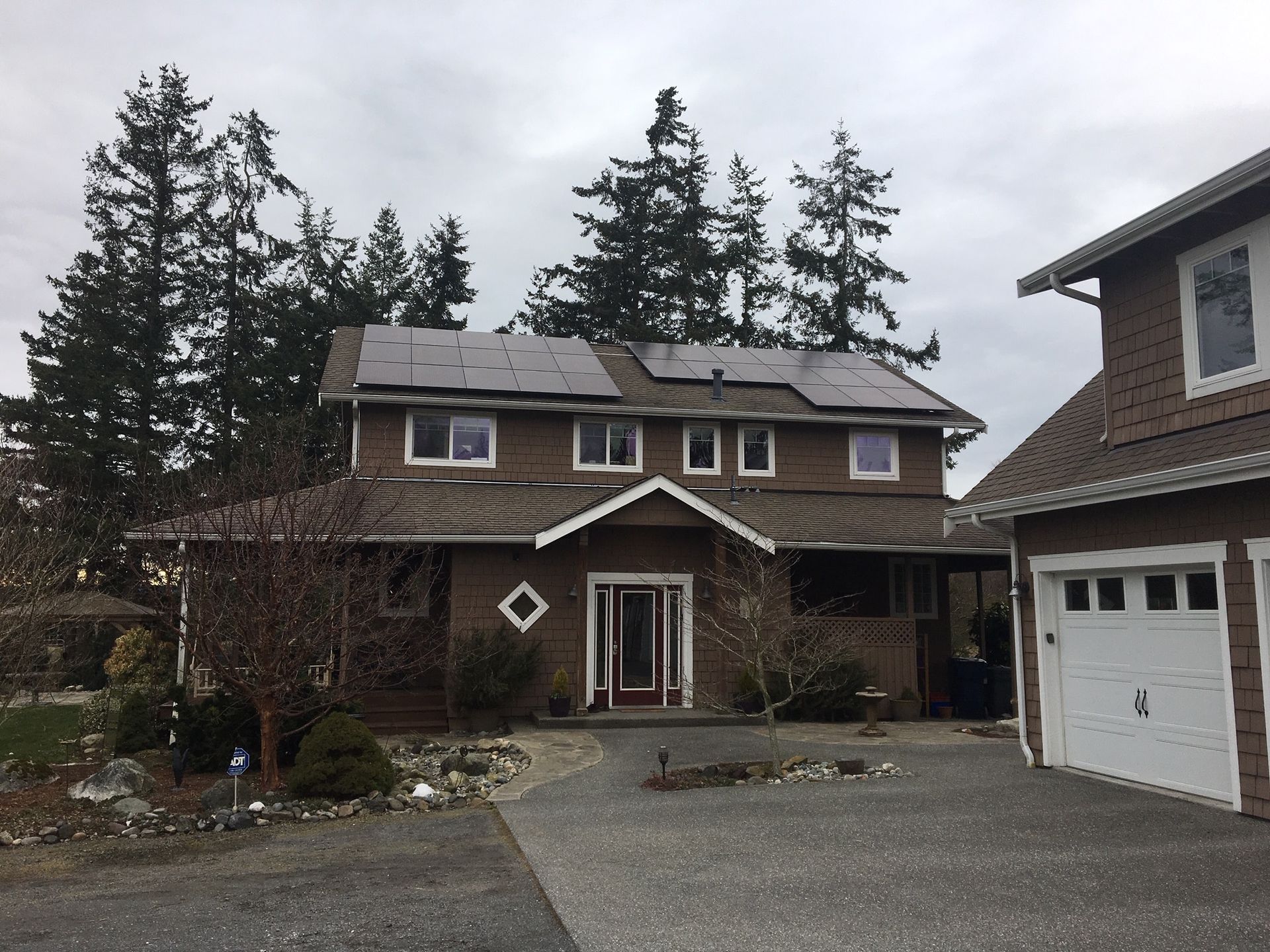 a large brown house with solar panels on the roof
