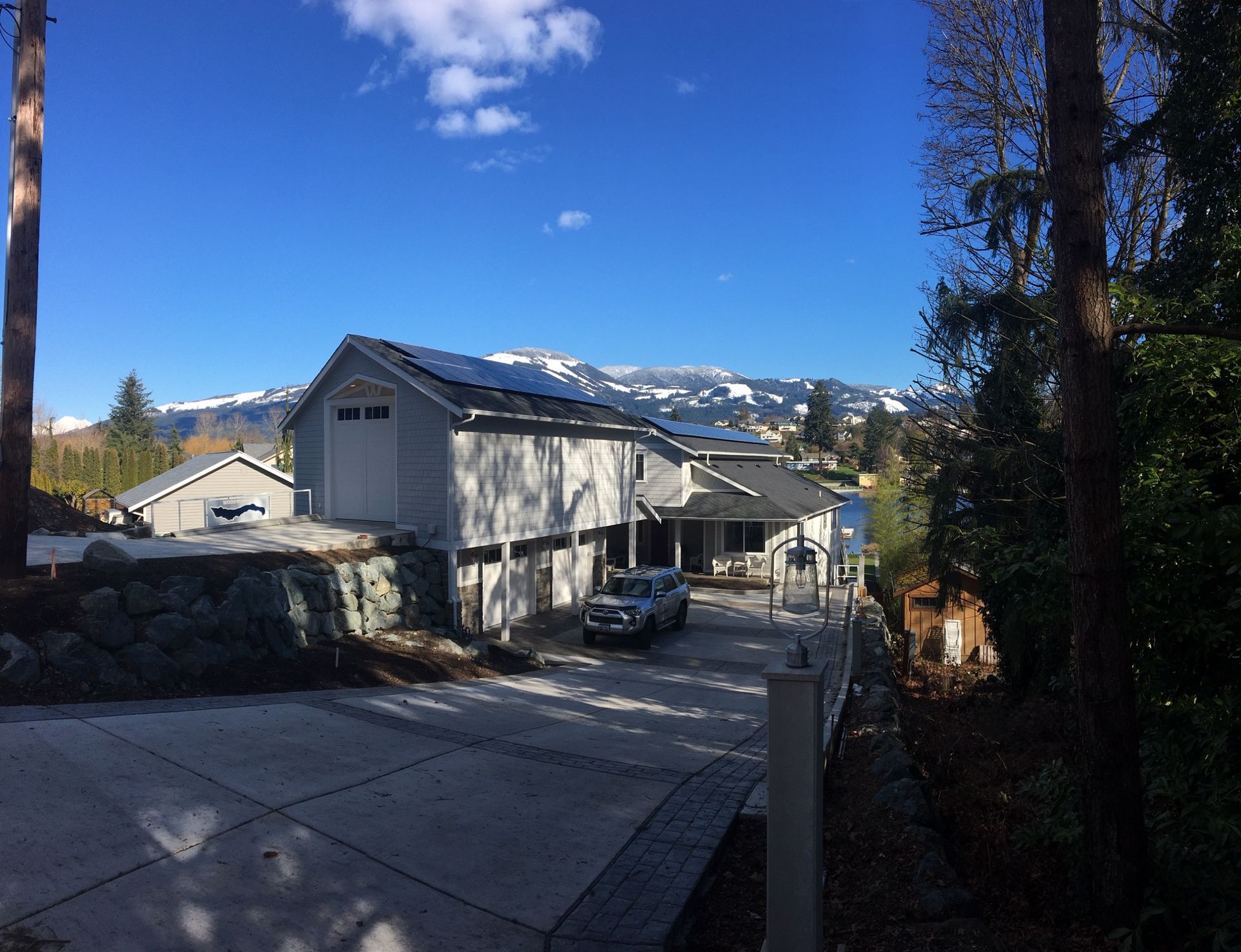 a car is parked in front of a house with mountains in the background