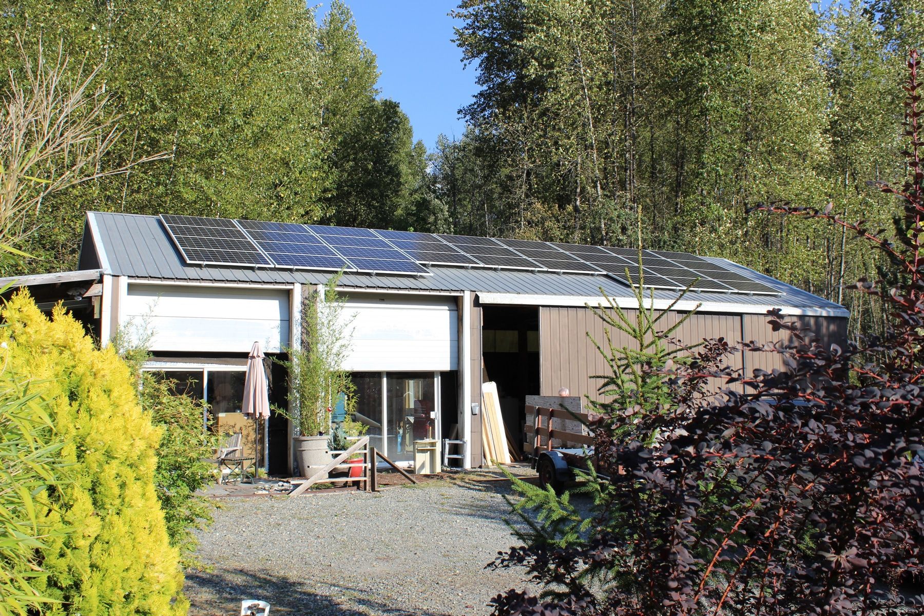 a house with solar panels on the roof is surrounded by trees
