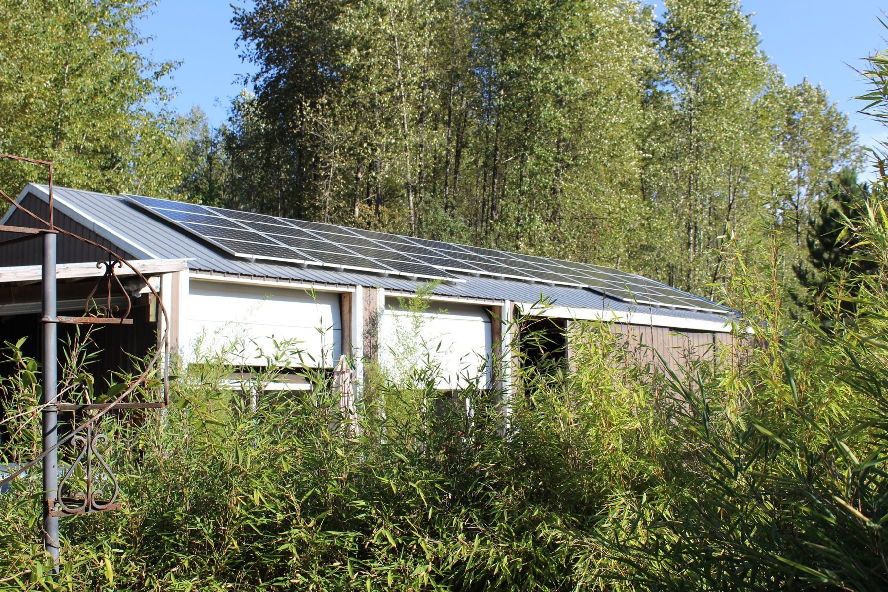 a small house with solar panels on the roof is surrounded by trees