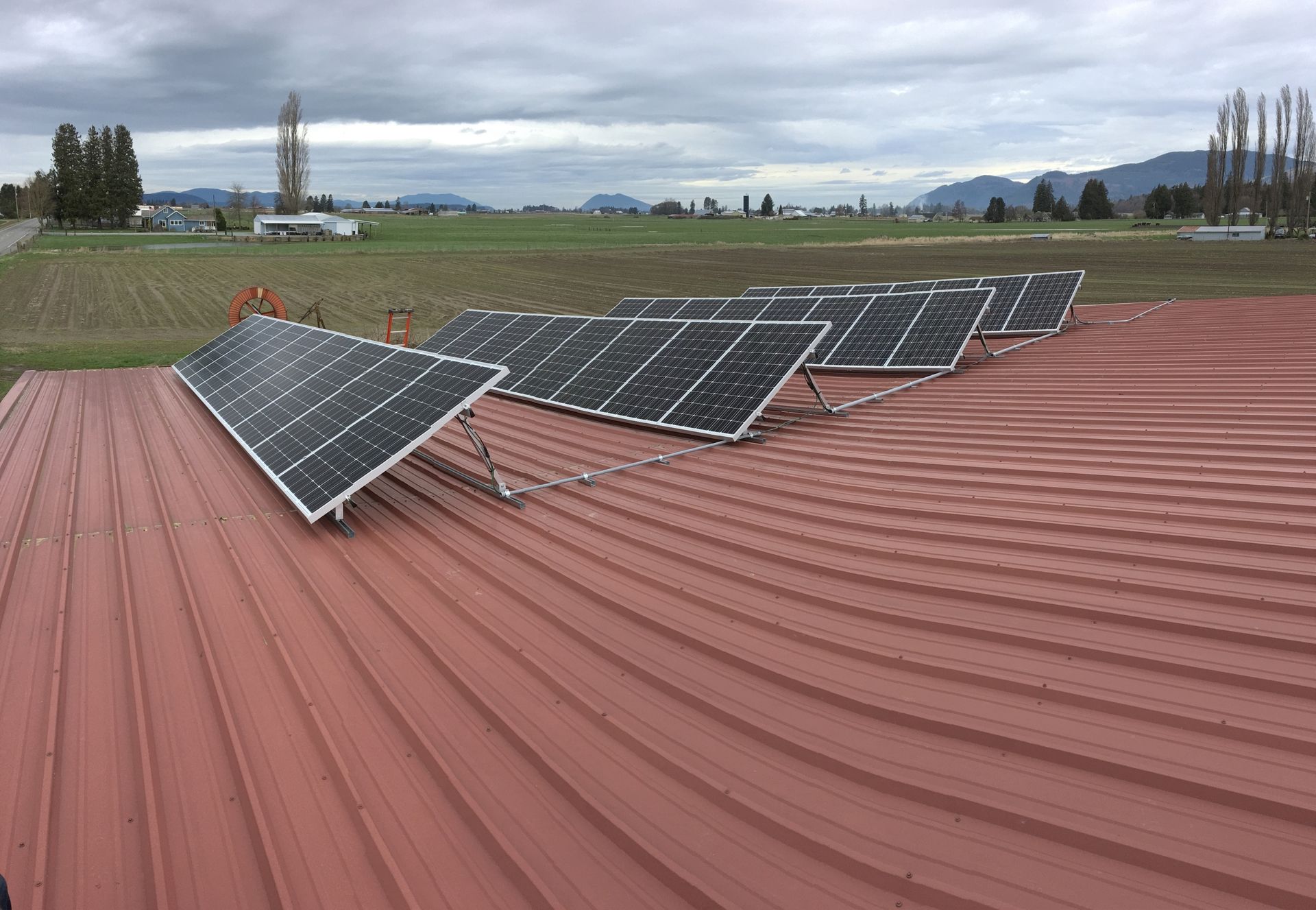 a row of solar panels are sitting on top of a red roof