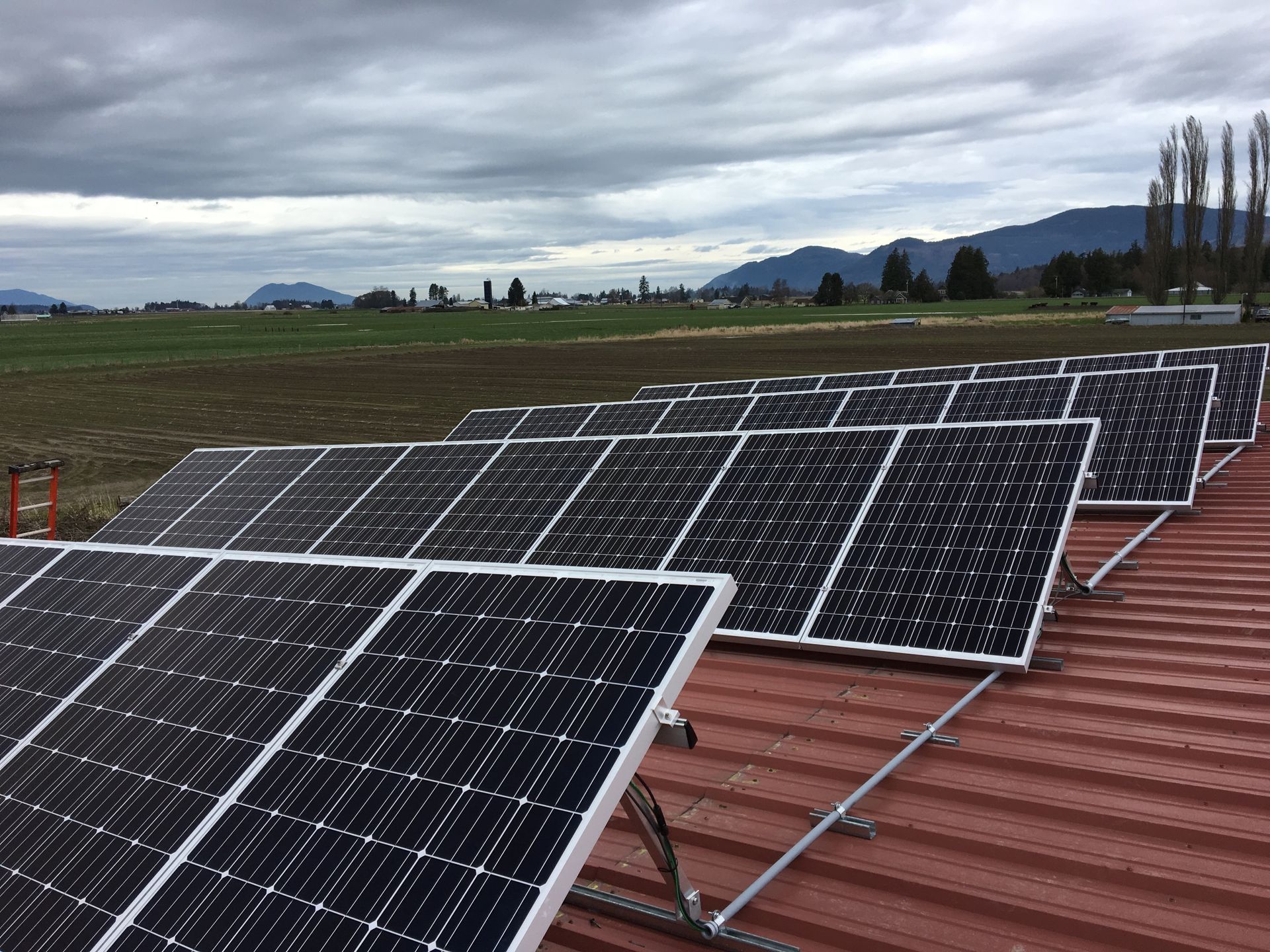 a row of solar panels is sitting on top of a red roof