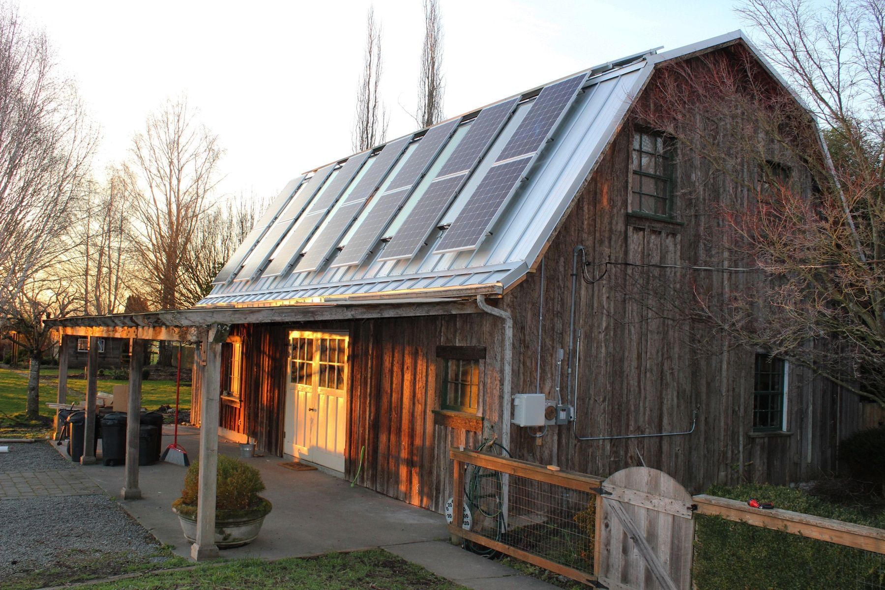 a wooden barn with solar panels on the roof