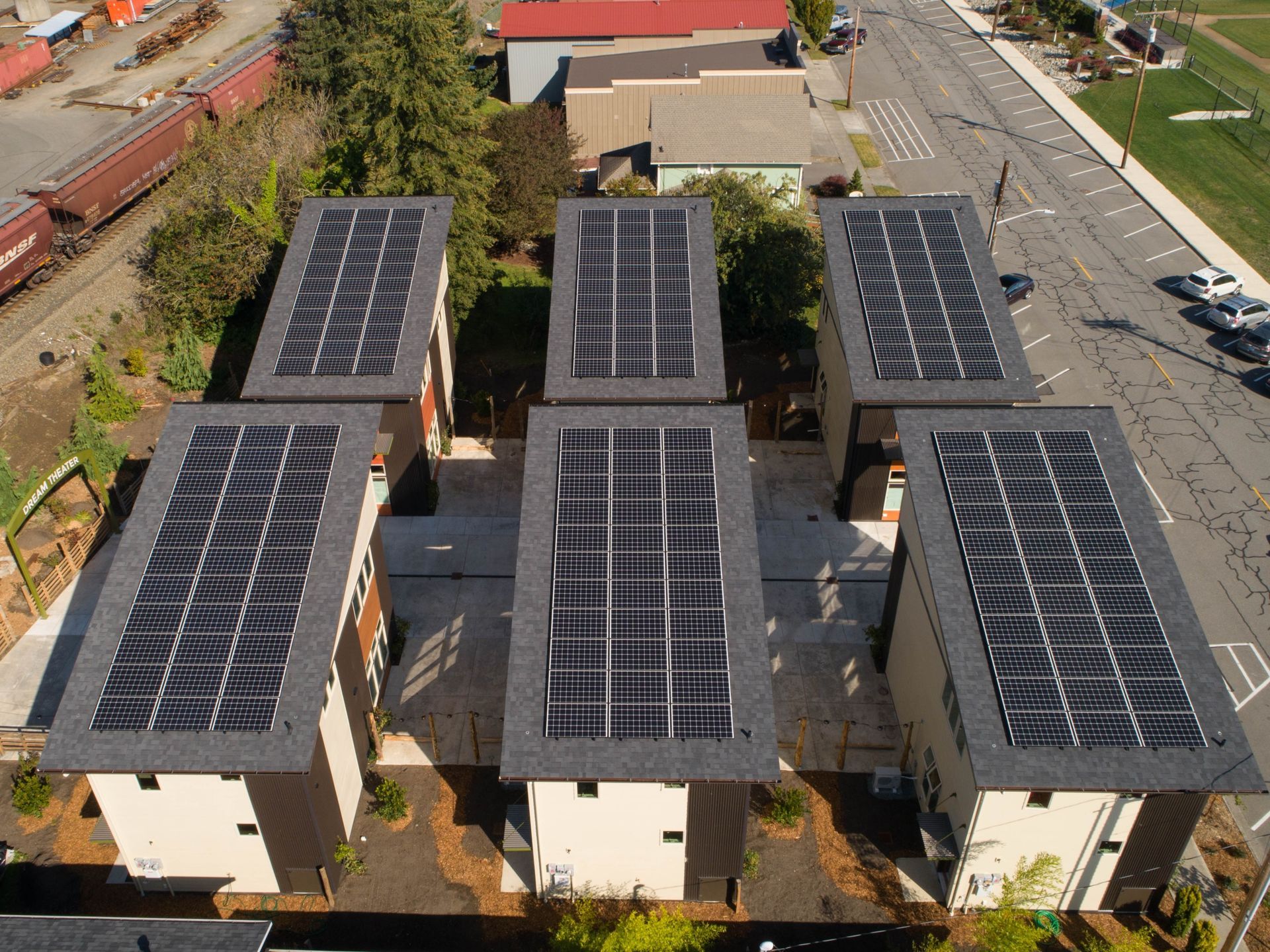 an aerial view of a row of buildings with solar panels on the roofs
