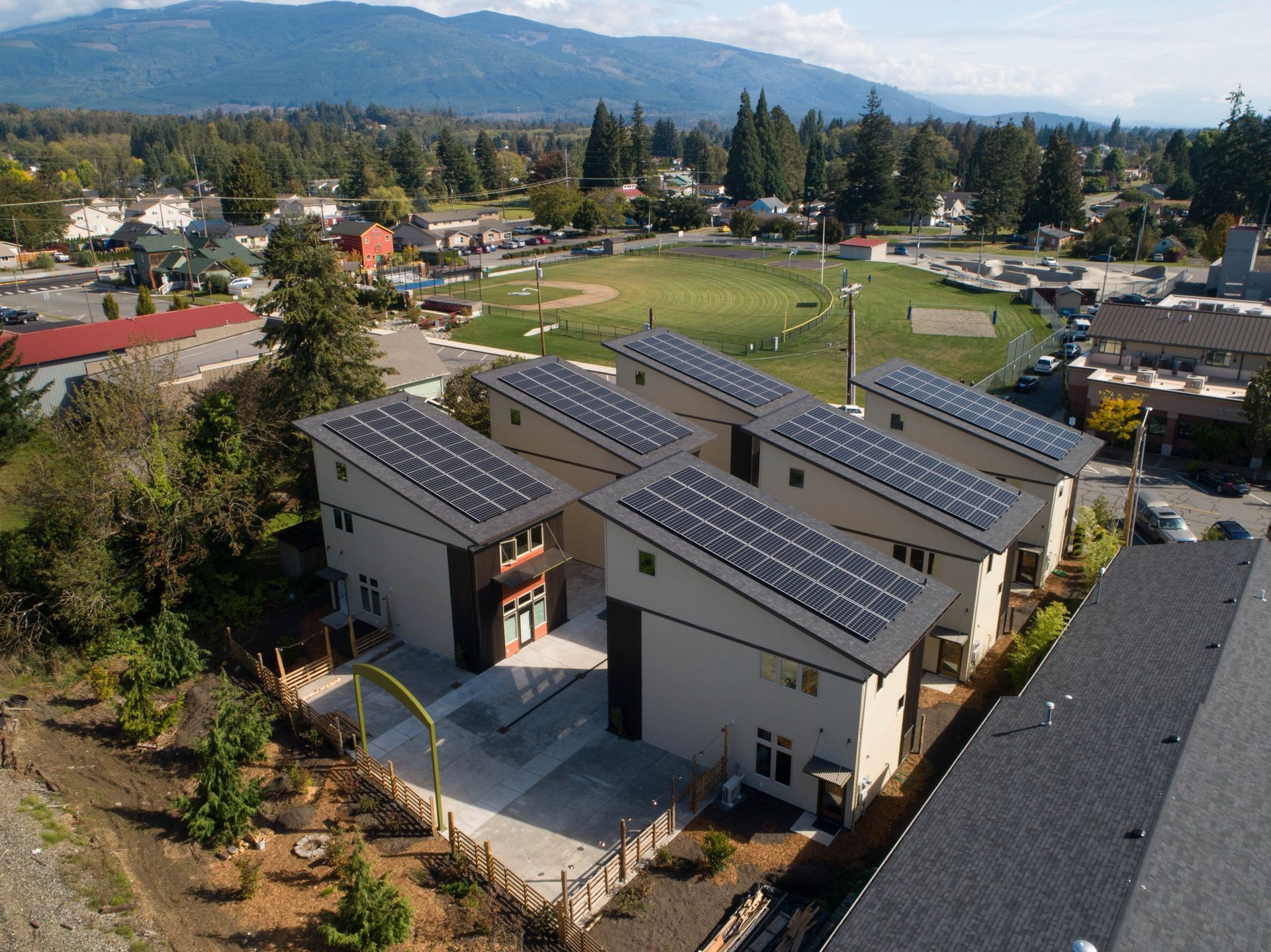 an aerial view of a row of houses with solar panels on the roof