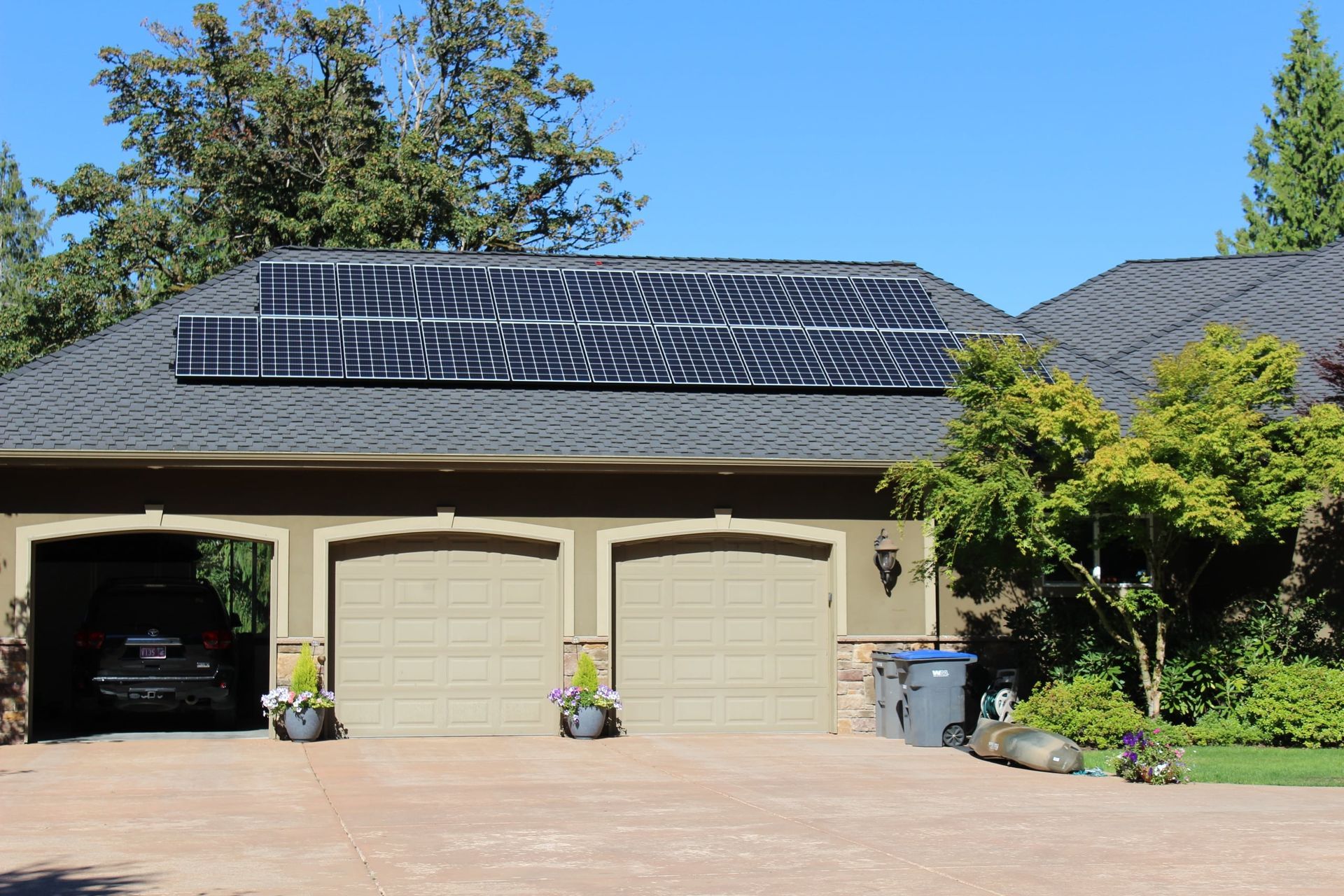 a house with three garage doors and solar panels on the roof