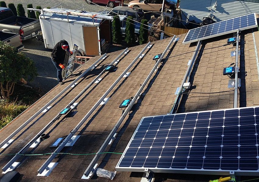 a man is installing solar panels on the roof of a house