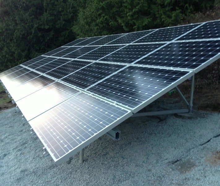a row of solar panels sitting on top of gravel