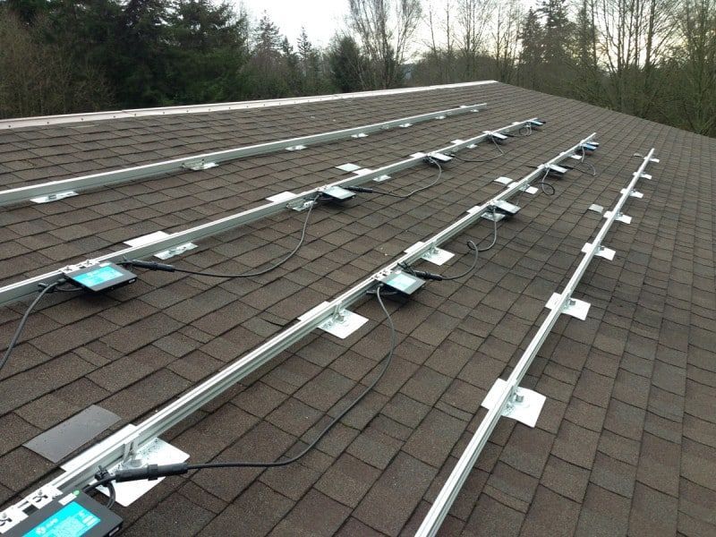 a row of solar panels on a roof with trees in the background