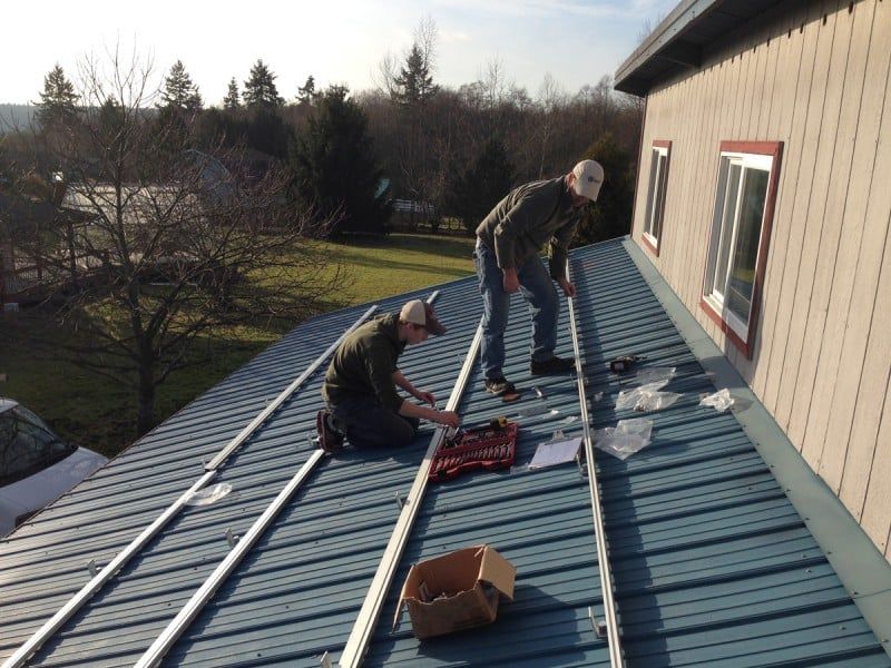 two men are working on the roof of a building