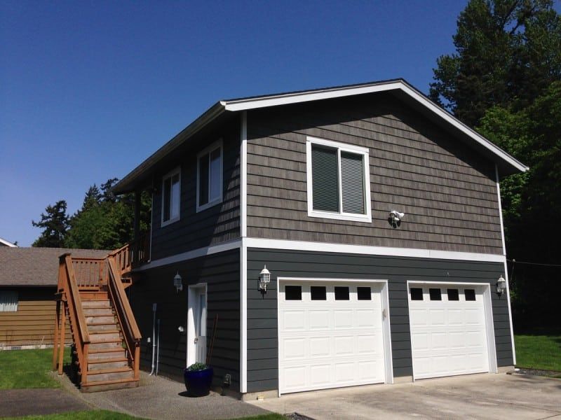 a large house with two garage doors and stairs